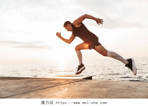 在海滩上跑步的男人在海滩上跑步的英俊强壮的年轻运动员的形象.